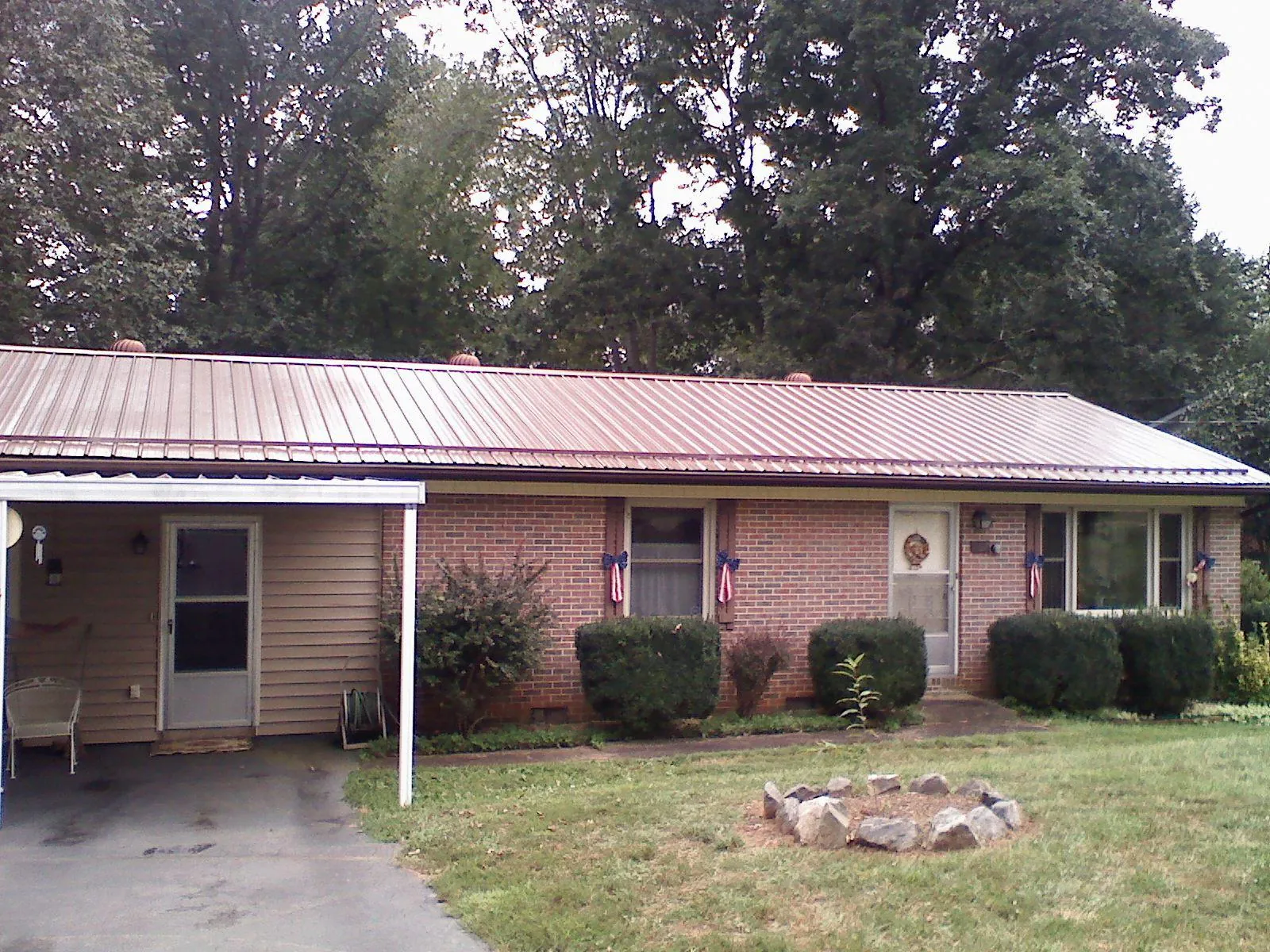 Bronze metal roof and carport on a brick ranch home — Roof Repair work by our crew in Greenacres
