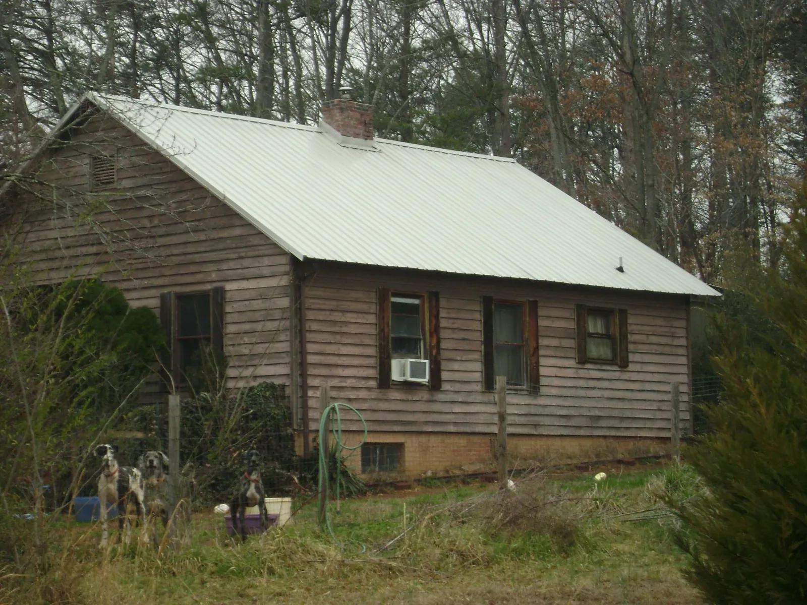 White metal roof on an old wood sided farmhouse, from a Metal Roof Installation job in Greenacres
